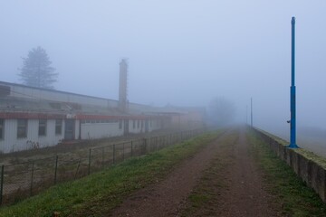 Fototapeta premium Gravel road on quay and abandoned bakery building