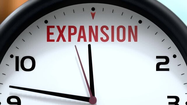 Expansion that is going to happen soon. Upcoming expansion, approaching in the near future. Expansion almost here, in a short time - a clock symbolizes a reminder that expansion is near.
