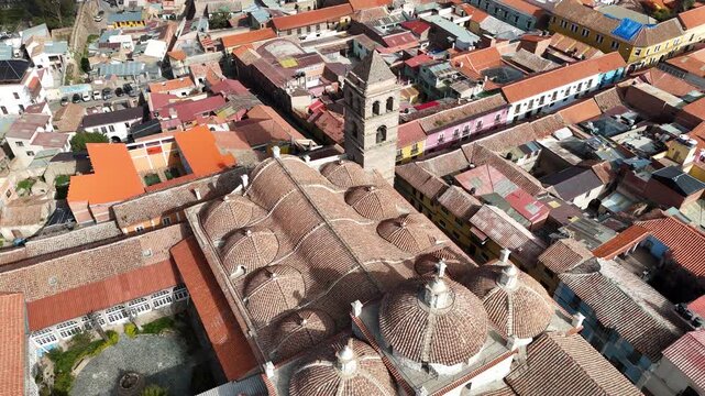 Cinematic aerial footage over the terracotta tile roofs and a historic colonial church tower in Potosi, Bolivia.