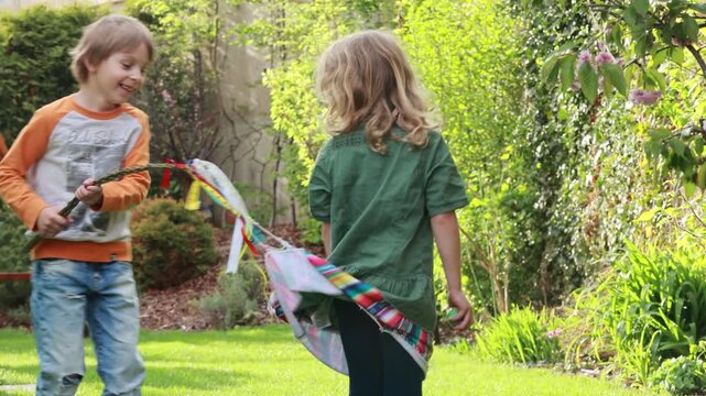 Happy children, siblings, enjoying Easter holiday together, tradition with handmade twig, braided whip made from pussy willow, traditional symbol of Czech Easter