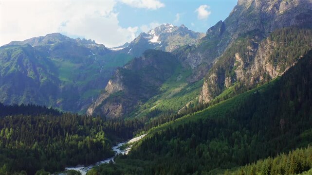 Dolra Valley opens in retreating aerial view beneath rugged Caucasus walls and a winding river near Mazeri, Svaneti, supporting trekking tourism, alpine geography and Georgian travel promotion.