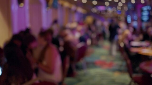 Blurred crowd inside vibrant restaurant lounge with warm bokeh lights and colorful interior atmosphere