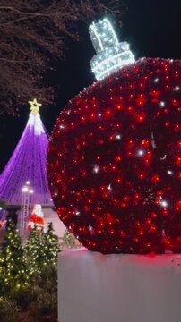 Giant illuminated Christmas ornament at festive night display