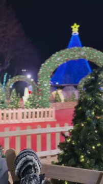 Two boys admiring illuminated Christmas tree at night