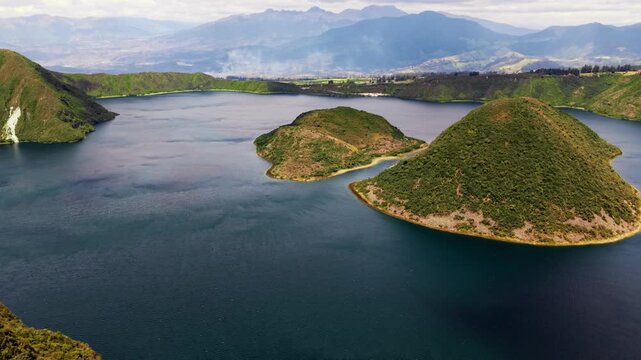 Backward aerial drone shot of the beautiful cuicocha crater lake inside a caldera in ecuador
