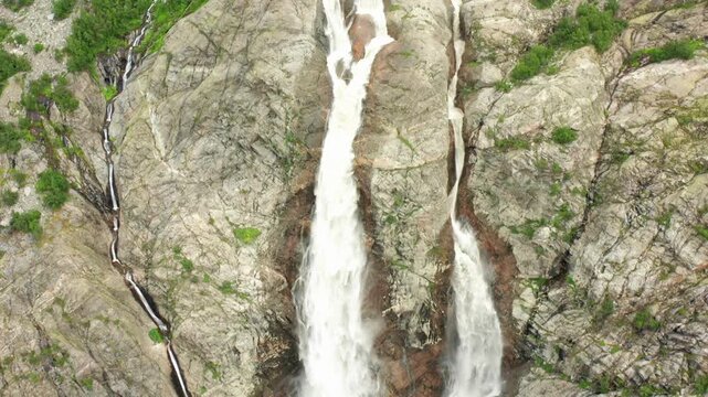 Shdugra Waterfall cascades in aerial view across split rock channels below Mount Ushba near Mazeri, Svaneti, supporting glacier tourism, hydrology research, erosion monitoring, Georgian travel media