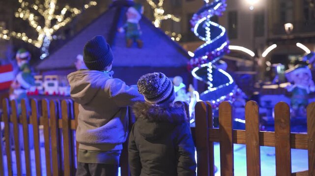 Children admiring christmas decorations in a festive village