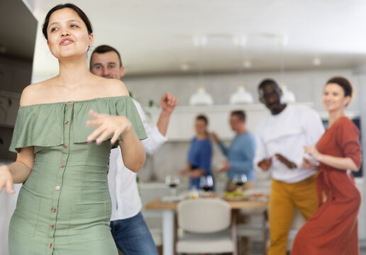 Multiethnic male and female friends doing active dances in kitchen