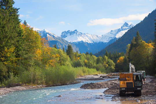 Cleanup operations in the Trettach riverbed using trucks and excavators. allgau landscape