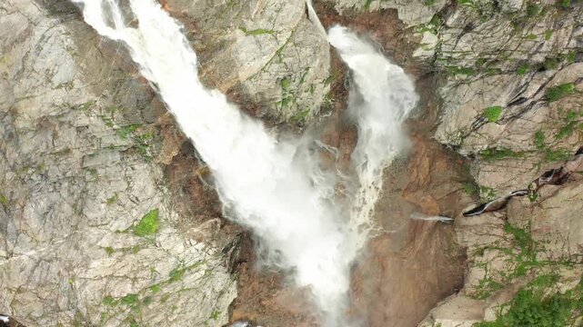 Shdugra Waterfall cascades in aerial view above converging rock channels below Mount Ushba near Mazeri, Svaneti, supporting watershed research, geomorphology studies and Georgian geography media.
