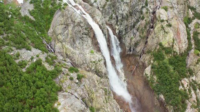 Shdugra Waterfall cascades aerial view across a steep rocky ravine below Mount Ushba near Mazeri, Svaneti, supporting freshwater research, mountain tourism, erosion mapping, Georgian documentary media