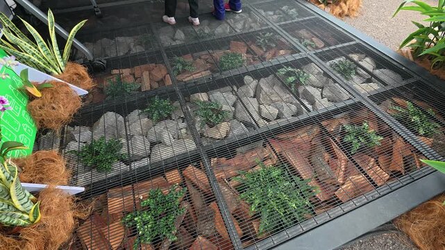 A steel frame building floor with elevated wire mesh walkway. It allows light to reach the garden below while creating a floating floor effect.