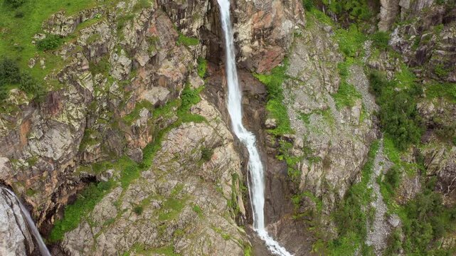Shdugra stream descends in landing aerial view through a narrow rocky channel near Mazeri, Svaneti, supporting watershed research, trail tourism, freshwater monitoring and Georgian mountain geography.