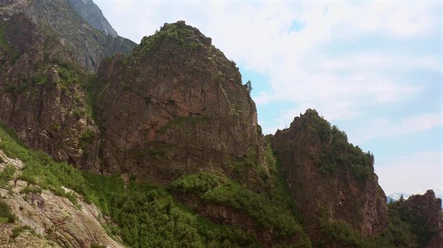 Rock cliffs rise in forward aerial view above Shdugra gorge near Mazeri, Svaneti, supporting geology tourism, mountain hazard mapping, trekking promotion and Georgian landscape documentation.