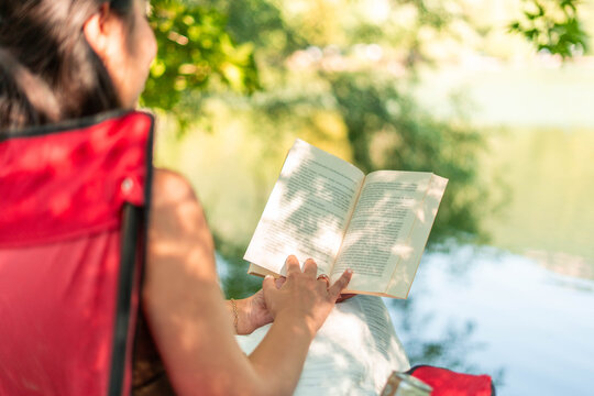 Woman relaxing reading book in natural park setting