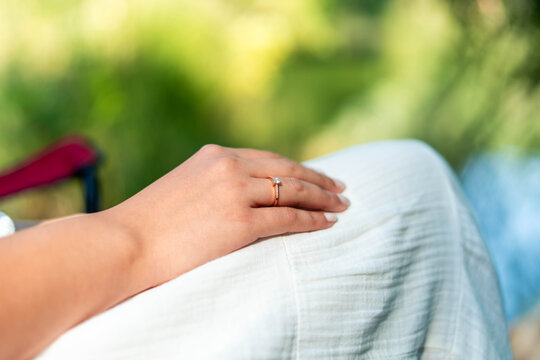 Woman wearing engagement ring on finger in nature