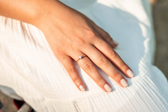 Woman's hand wearing elegant engagement diamond ring