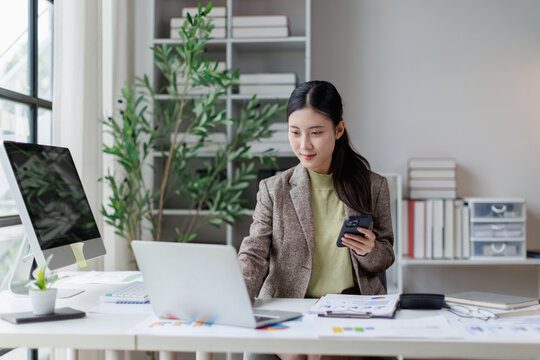 Asian business woman working on laptop and smartphone