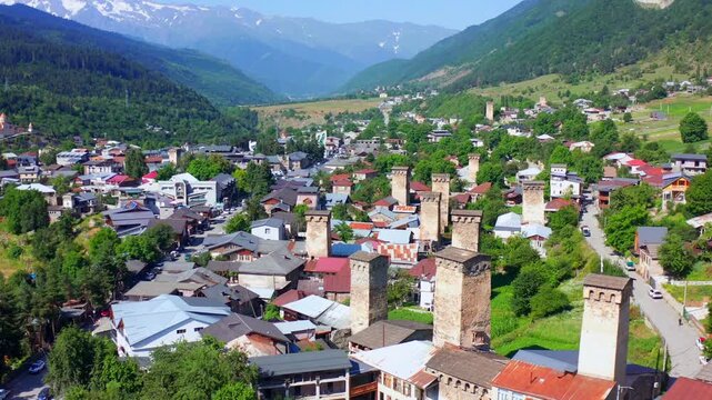 Mestia skyline opens in forward aerial view with medieval Svan towers, village roofs and Caucasus valleys, supporting mountain tourism, heritage branding, regional geography, Georgian travel campaigns