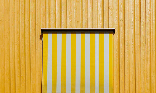 Yellow striped awning on wooden facade
