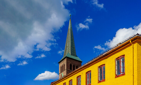 Kampen church steeple and yellow building against blue sky