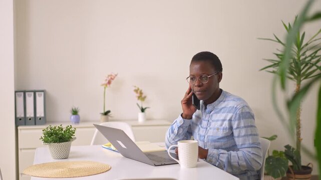 African-american businesswoman talking on phone in modern office