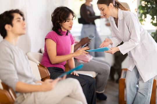 Malaysian woman standing in the reception area after an interview and chatting with a nurse to get a medical record before applying for a job