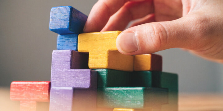 Business strategy and rational thinking with hands placing geometric shaped wooden blocks