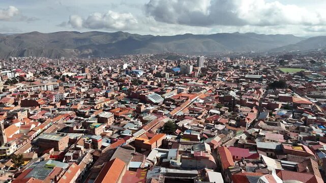 Wide aerial footage of the historic colonial city of Potosi, Bolivia, featuring thousands of red-tiled roofs nestled in the Andes.