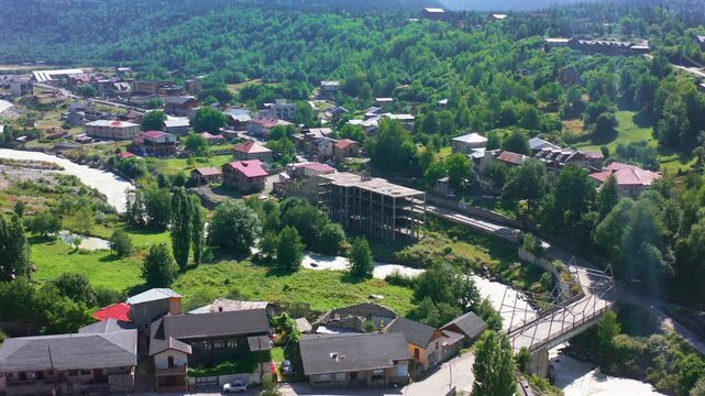 Mestia riverfront advances in aerial view beside homes, roads and a mountain channel, supporting infrastructure planning, settlement geography, tourism development and regional mapping media.