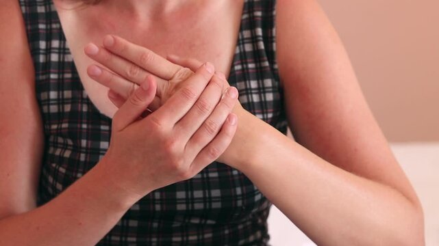 Woman applying soothing cream to her hands after sunbathing. Concept of summer skin care, treatment of sunburn, sun allergy (photodermatitis) and intensive moisturizing of dry skin after sunbathing