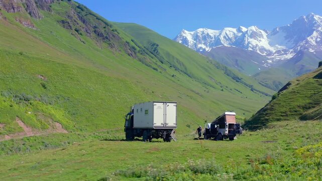 Expedition vehicle descends in landing aerial view on a remote valley track beneath Shkhara near Ushguli, supporting overland travel, mountain logistics, trekking access and Georgian adventure tourism