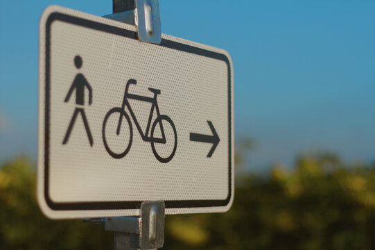 German pedestrian and bicycle route sign with arrow outdoors in evening light
