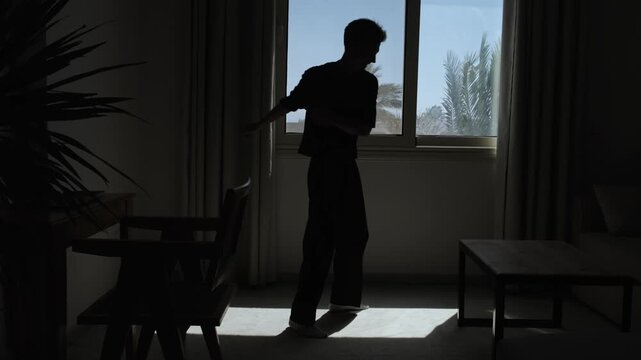 Intense emotional breakdown in silhouette as distressed man gestures frantically and holds his head in psychological pain, emotional turmoil and slow motion