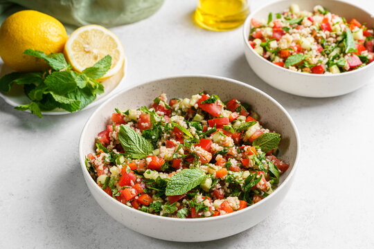Tabbouleh salad with bulgur, tomato, and cucumber on a light background.