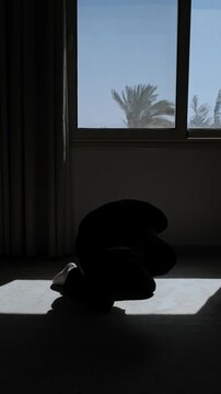 Distressed man falls to his knees and covers his face during an emotional collapse, expressing despair, helplessness and devastating realization in dramatic slow motion, vertical