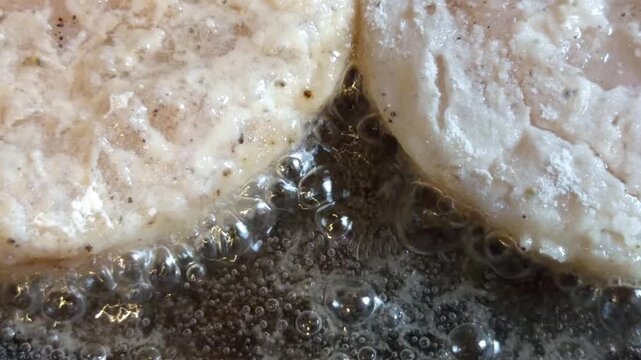 Hot oil bubbles around pieces of fillet during frying