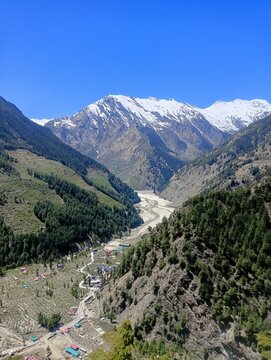  Himalayan valley with snow capped mountains and river in Uttarakhand, India