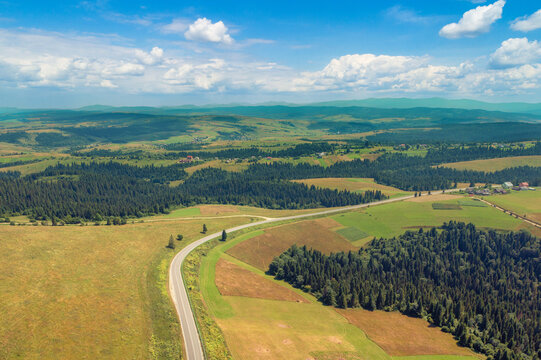 Panoramic aerial view of the countryside, country road, and cultivated and uncultivated fields in the hills