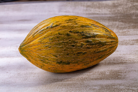 Piel de sapo melon on textured surface with natural lighting and warm tones
