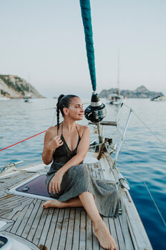 A woman sits on a sailboat deck during a summer vacation in Ibiza
