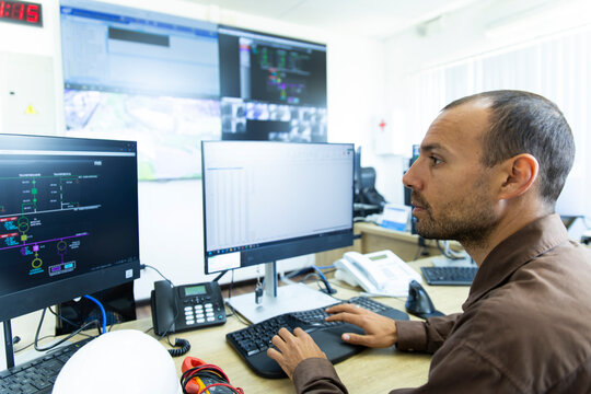 Technician monitors data at an indoor wind farm control room