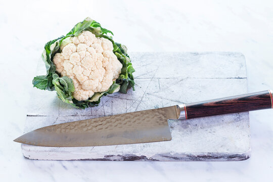 White cauliflower on chopping board, knife