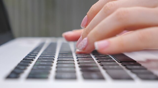 Female hands typing some text on keyboard of notebook. Unrecognizable woman working at laptop outdoor. Girl chatting with somebody or browsing internet. Freelancer using pc. Detail view