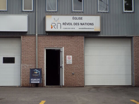 Gatineau, Quebec, Canada &ndash; June 28, 2026: An "Eglise R&eacute;veil des Nations churc" sign is mounted above an open doorway between two garage doors on a building  at 485 Bd Saint-Ren&eacute; E.