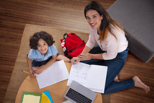 Top view of mother and son looking above while doing home work