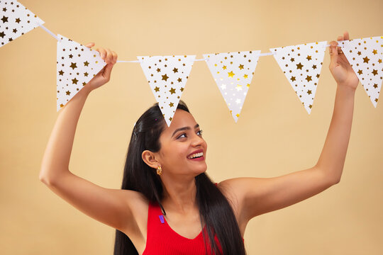 Young woman decorating home with bunting flags