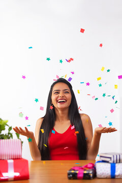 Cheerful young woman celebrating her birthday at home