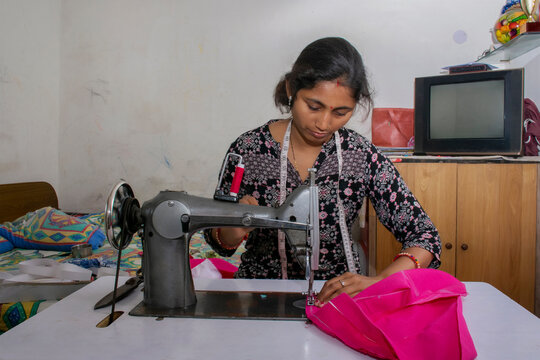 woman working on sewing machine as tailor