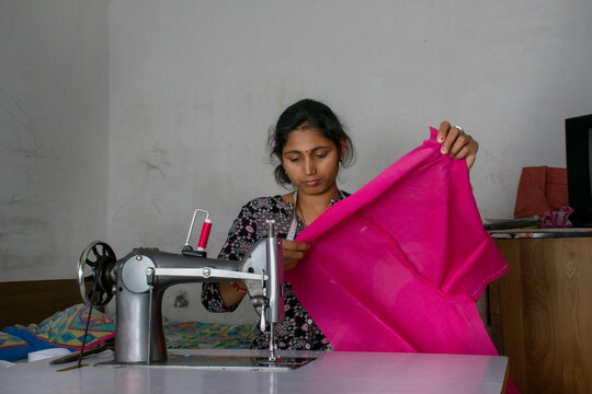 woman working on sewing machine as tailor